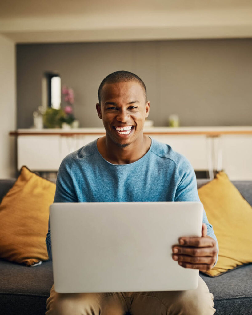 Portrait of a handsome young man using a laptop at home